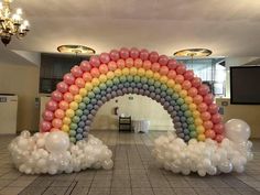 an arch made out of balloons in the shape of a rainbow