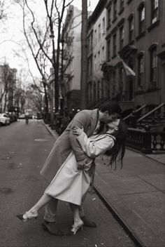 a man and woman kissing on the street