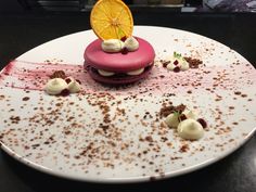 a plate topped with a dessert covered in icing and toppings on top of a table