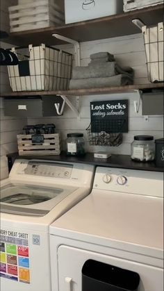 a washer and dryer in a laundry room with baskets on the shelves above