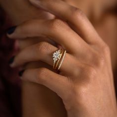 a woman's hand with two rings on her finger and one ring in the middle