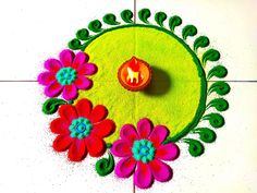 a small lit candle is placed on top of a green mat with pink and red flowers