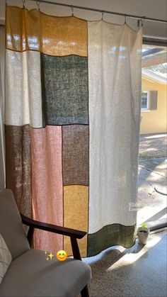 a chair sitting next to a window covered in curtains