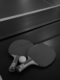 two ping pong paddles resting on top of a table