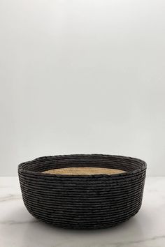 a black basket sitting on top of a white table