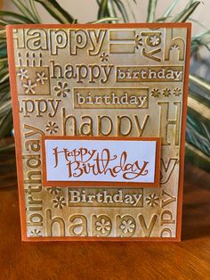 a happy birthday card on a table next to a potted plant