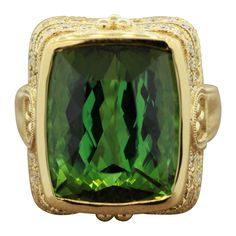 A large cocktail ring made in an antique style with milgrain settings and decorative filigree. It features a luscious green tourmaline weighing 17.85 carats with no visible inclusions. It is accented by 0.86 carats of round brilliant cut diamonds which are set on the basket. Made in 14k yellow gold, a fabulous cocktail ring ready to be worn. Ring Size 7 Cocktail Ring Diamond, Green Tourmaline Jewelry, Gold Cocktail Ring, Tourmaline Jewelry, Gold Cocktail, Diamond Cocktail Rings, Diamond Gold, Green Tourmaline, Round Brilliant Cut Diamond