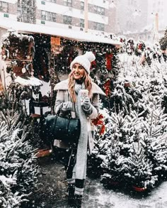 a woman standing in front of christmas trees