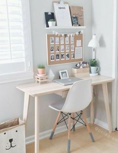 a desk with a laptop computer on top of it next to a bag and lamp