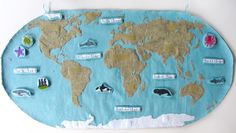 a world map with pins and magnets attached to the back of it on a wall