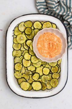 a white plate topped with cucumbers and sauce