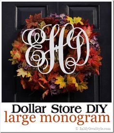 an autumn wreath with the letter monogrammed in white on a black front door