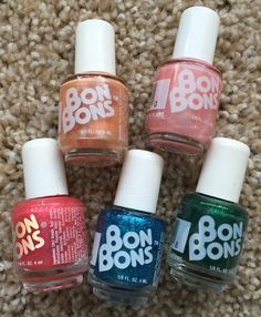 four nail polish bottles sitting on top of a carpet