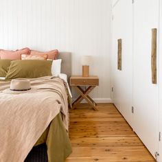 a bedroom with white walls and wooden floors