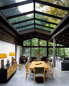 a dining room with a table and chairs under a glass roof