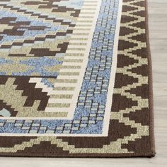 a brown and blue area rug on top of a wooden floor