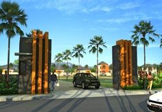 a car is parked in front of some tall pillars and palm trees on the street