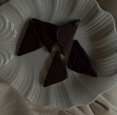 four pieces of chocolate on a white plate