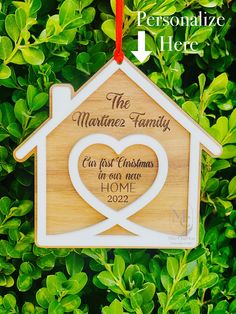 a personalized ornament hanging from a tree in front of green leaves with the words, the matinez family our first christmas in our new home