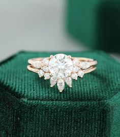 a diamond ring sitting on top of a green velvet box