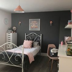 a bedroom with grey walls and white furniture