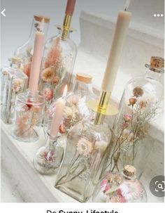 there are many glass bottles with flowers in them