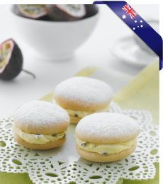 three pastries are sitting on a doily next to a bowl of fruit and an australian flag