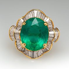 This spectacular cocktail ring is centered with an oval mixed cut emerald, weighing an estimated 8.21 carats, in a four-prong setting. The center is accented with a total of sixty-six (66) channel set, baguette cut diamonds. The ring measures 21.2mm at the top, rises 9.1mm above the finger, tapering to 3.0mm wide and 0.8mm thick at the base of the shank. The ring is currently size 7. Luxury Marquise Emerald Ring, Art Deco Oval Emerald Ring With Brilliant Cut, Gia Certified Oval Emerald Ring In Art Deco Style, Luxury Oval Emerald Ring With Prong Setting, Timeless Oval Emerald Ring For Formal Occasions, Dazzling Oval Emerald Ring For Formal Occasions, Elegant Oval Emerald Ring For Formal Occasions, Formal Art Deco Oval Emerald Ring, Diamond Cocktail Ring