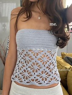 a woman wearing a crochet top and white shorts