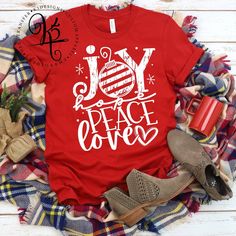 a red shirt with the words joy and peace on it, surrounded by other items