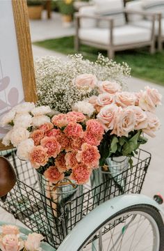 a basket full of flowers sitting on the back of a bicycle