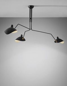 three lights hanging from the ceiling in an empty room with grey walls and flooring