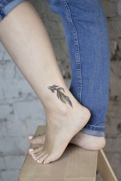 a woman's foot with a small flower tattoo on her left side calfocks