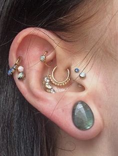 a close up of a person with ear piercings on their ears and behind the ear