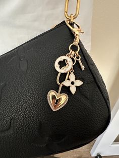 a close up of a purse with a heart and key on the chain attached to it