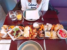 a woman sitting at a table filled with food