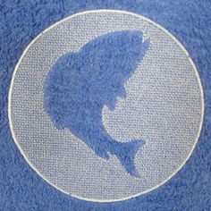 a blue towel with a white shark on it's side in the shape of a circle