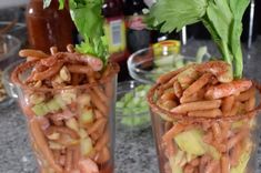 two glasses filled with food sitting on top of a counter