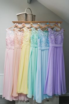 there are many different colored dresses hanging on the clothes rack in front of each other