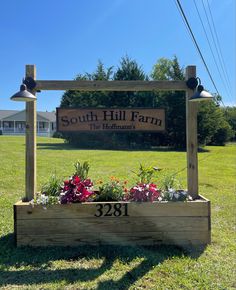 the sign for south hill farm with flowers in it