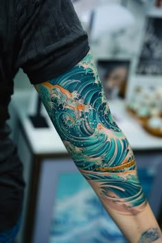 a man's arm with an ocean wave tattoo on it