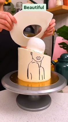 a person holding a paper towel over a cake on a plate with the word beautiful written on it