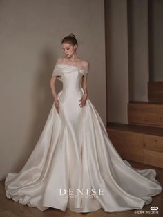 a woman in a white wedding dress standing on stairs with her hands on her hips