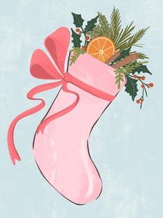 a pink christmas stocking with oranges and holly on the top, hanging from a red ribbon