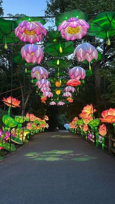 an outdoor walkway decorated with lanterns and flowers