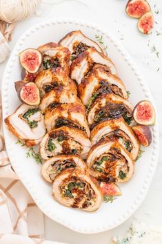 sliced chicken with figs and herbs on a white platter