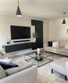 a living room filled with furniture and a flat screen tv mounted to the side of a wall