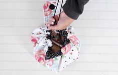 a person holding an umbrella in their hand with flowers on the outside and polka dots on the inside