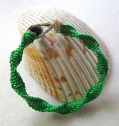 a close up of a green bracelet on a shell