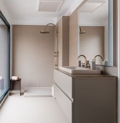 a bathroom with a sink, shower and large window overlooking the outside area in front of it